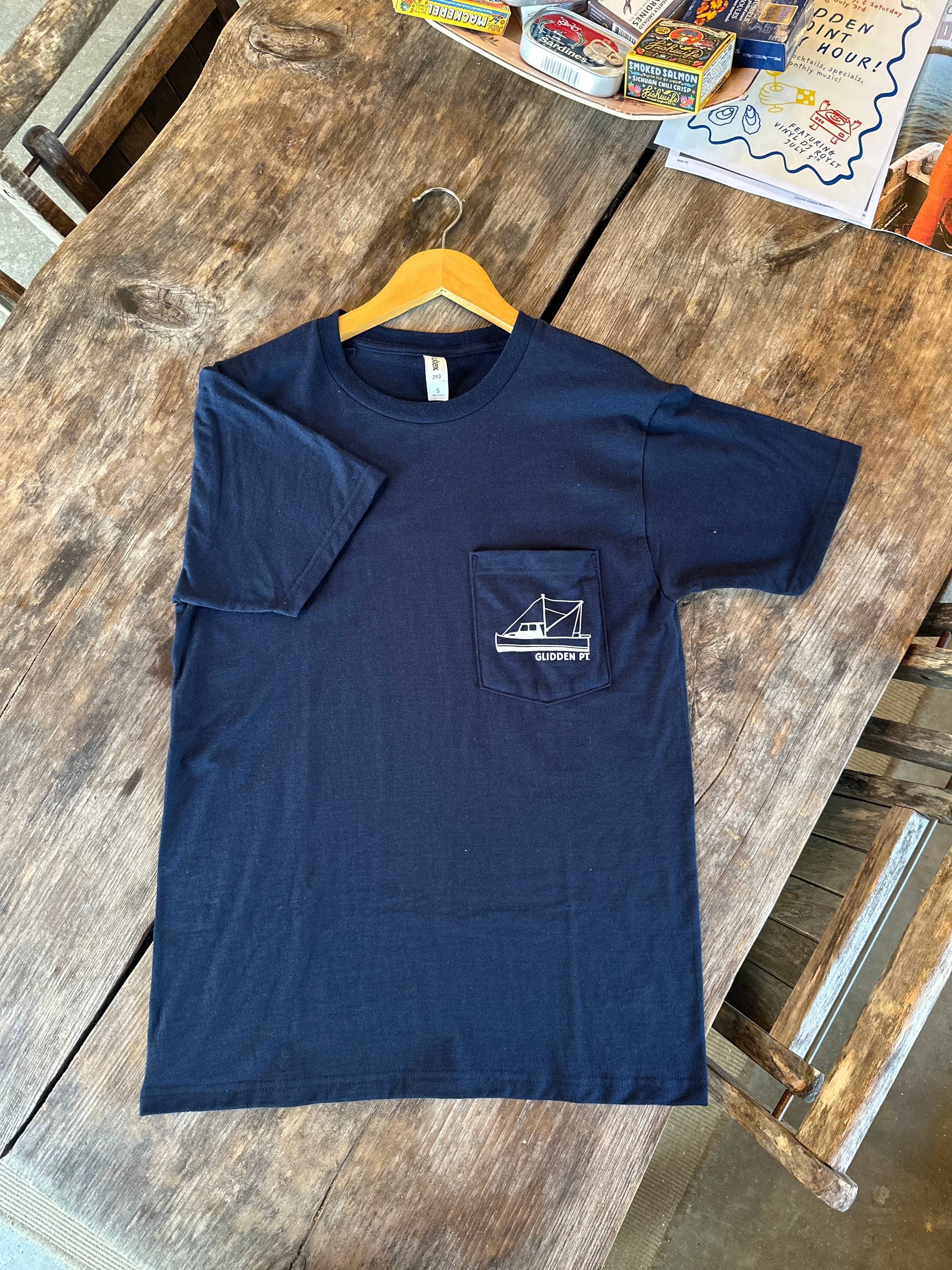 Navy blue t-shirt with a pocket design on a wooden surface